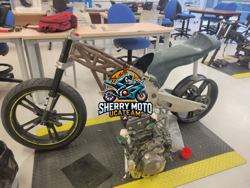Vista detallada del motor y la estructura de la motocicleta Sherry Moto en proceso de ensamblaje, mostrando avances en su diseño y fabricación.